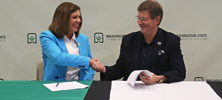 WSCO2MC agreement. WSCO President Dr. Vicky Wood shaking hands with Marietta College President Dr. William Ruud